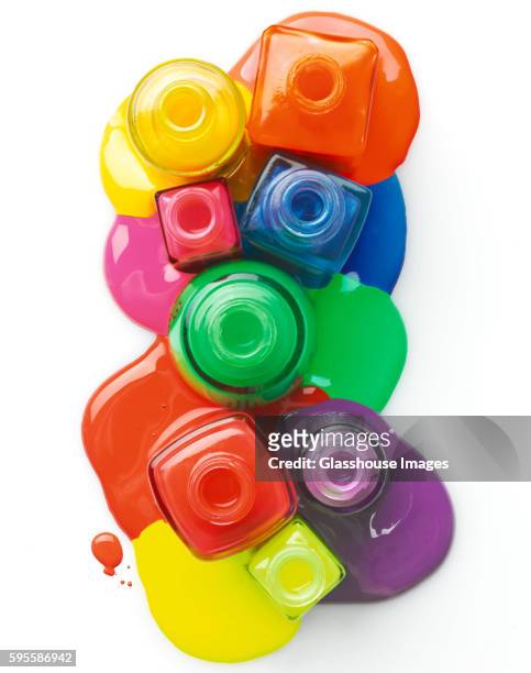 colorful nail polish spilling from bottles, high angle view, - nail varnish stock pictures, royalty-free photos & images