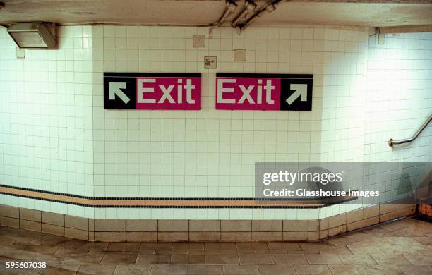 two subway exit signs pointing in opposite directions - exit sign stock pictures, royalty-free photos & images