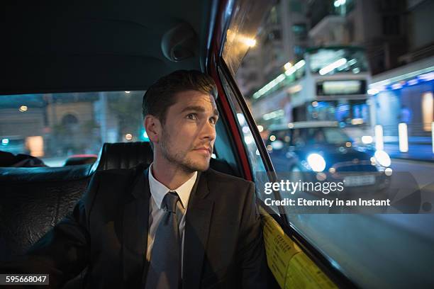 businessman riding in back seat of car, hong kong. - car front view foto e immagini stock