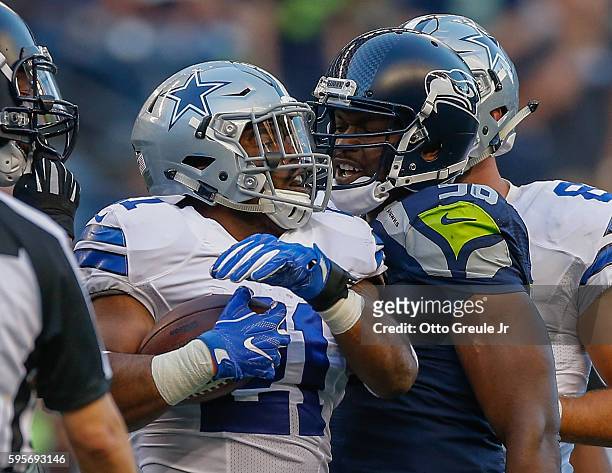 Running back Ezekiel Elliott of the Dallas Cowboys exchanges words with defensive end Cliff Avril of the Seattle Seahawks after being stopped on a...