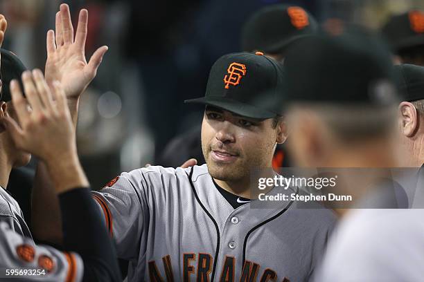 Starting pitcher Matt Moore of the San Francisco Giants is congratulated in the dugout by teamates after Corey Seager of the Los Angeles Dodgers...