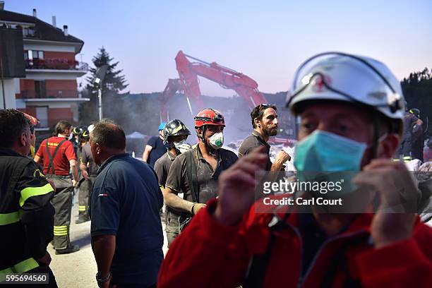 Emergency workers search the rubble of a building that was destroyed during an earthquake, on August 25, 2016 in Amatrice, Italy. The death toll in...