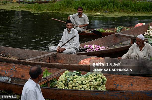 In this photograph taken on August 25 Kashmiri Muslims gather with their boats laden with vegetables at the floating vegetable market on Dal Lake at...