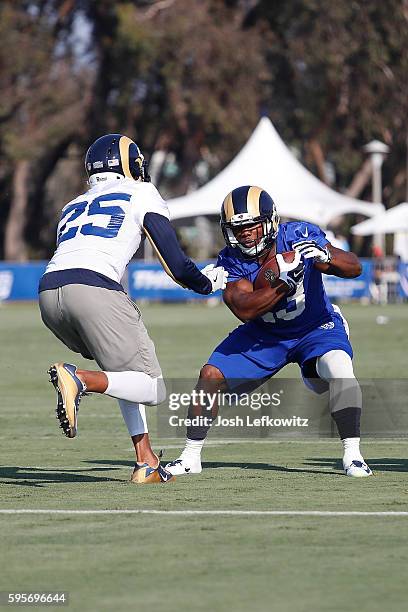 Benny Cunningham of the Los Angeles Rams tries to avoid being tackled by T.J. McDonald during practice at Crawford Field on August 25, 2016 in...