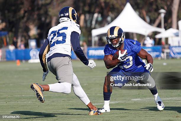 Benny Cunningham of the Los Angeles Rams tries to avoid being tackled by T.J. McDonald during practice at Crawford Field on August 25, 2016 in...