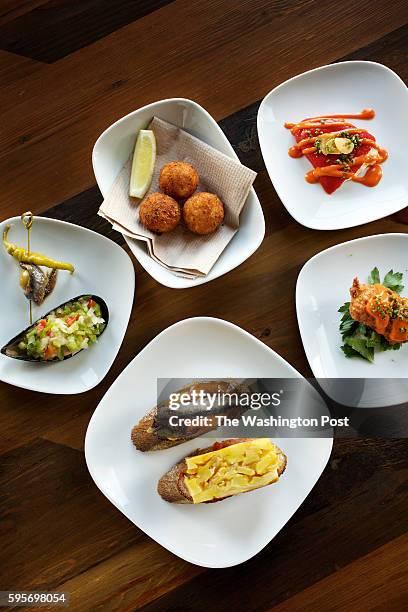 Variety of pintxos: Gilda with Marinated Mussels; Shrimp Croquettes; Cauliflower-Stuffed Piquillo; Cod Fitters and Escalivada Montadito plated with...