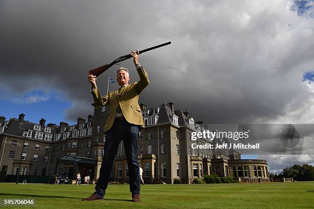 Auctioneer Gavin Gardiner holds a 12-bore Royal de Luxe model self-opening sidelock ejector gun by Holland and Holland at Gleneagles Hotel on August...