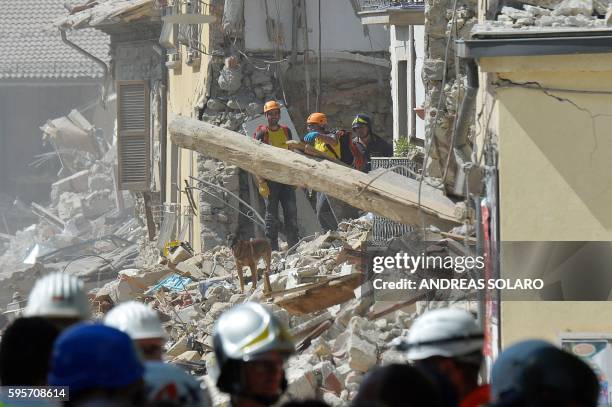 Rescue workers search through the rubble of an earthquake damaged building in the central Italian village of Amatrice on August 26 two day after a...