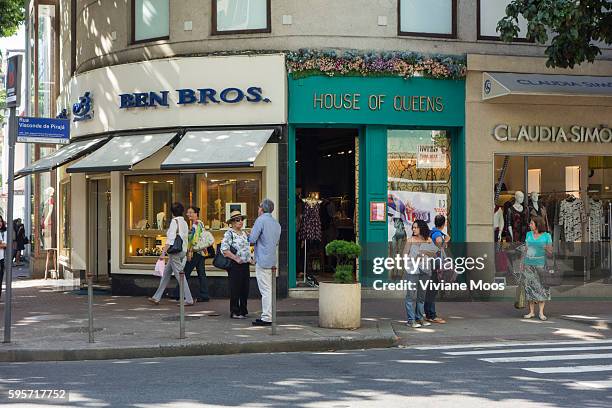 Central Ipanema street corner and elegant shops for the wealthy. Locals meeting and stroll on the sidewalk.