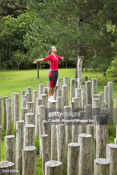 woman standing on tree stumps - 002195 stock pictures, royalty-free photos & images