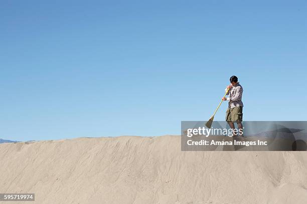 man sweeping on sand dune - vegen stockfoto's en -beelden