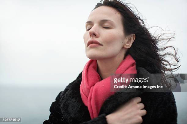 woman with eyes closed - überzieher stock-fotos und bilder