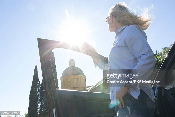 woman looks towards church steeple from car door - the dome 55 stock pictures, royalty-free photos & images