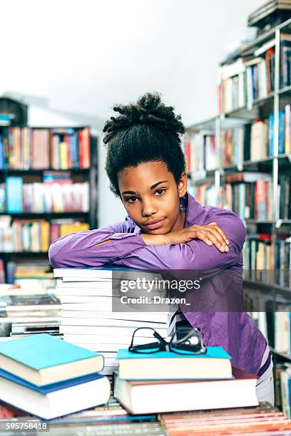 afro-americano franzindo a testa em pilha de livros na biblioteca - nerd girl - fotografias e filmes do acervo