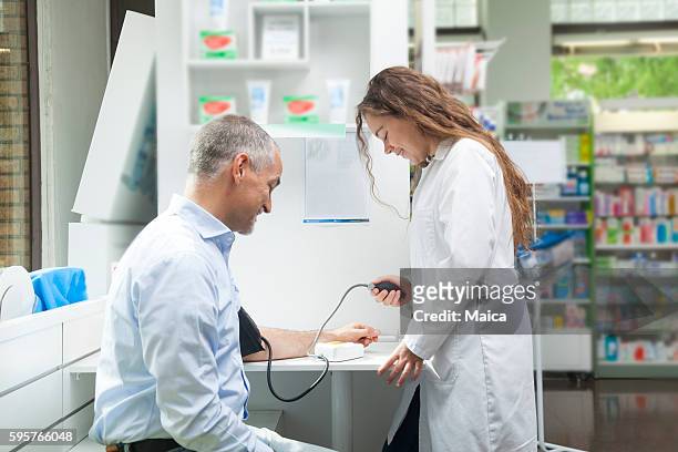 成熟した男に血圧を取る女の子 - high blood pressure ストックフォトと画像