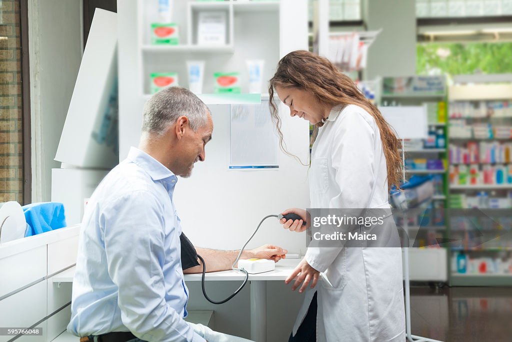 Girl taking blood pressure to mature man