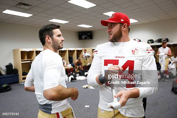 Christian Ponder of the San Francisco 49ers talks with Joe Staley in the locker room following the game against the Denver Broncos at Sports...
