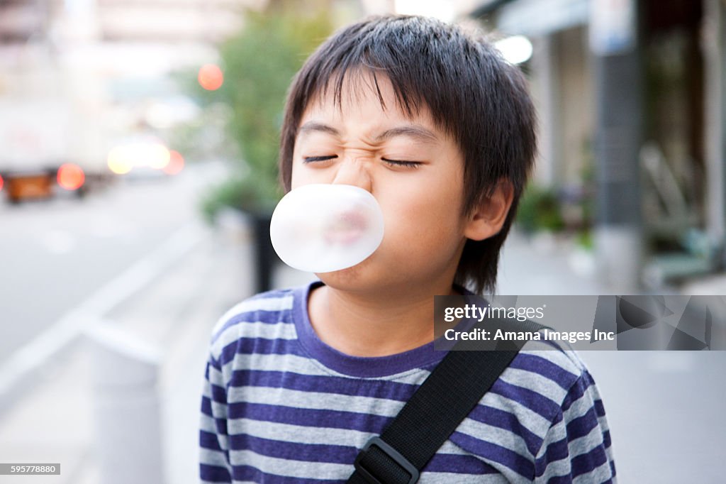 Boy blowing up a bubble gum