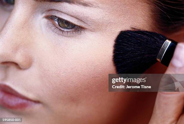 woman appying blusher with brush, close-up of face - rouge stock-fotos und bilder