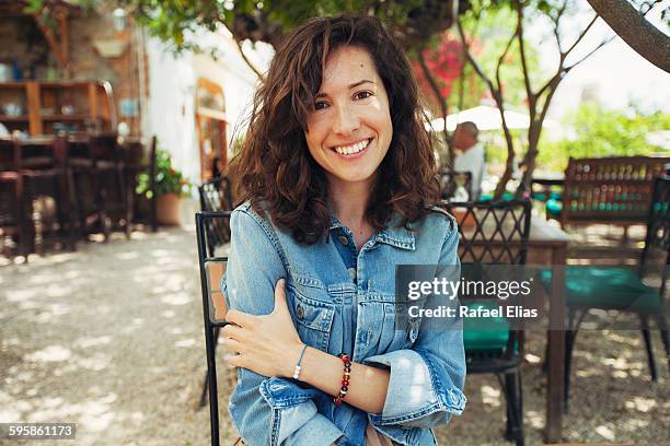 pretty smiling woman in terrace bar - wavy hair stock pictures, royalty-free photos & images