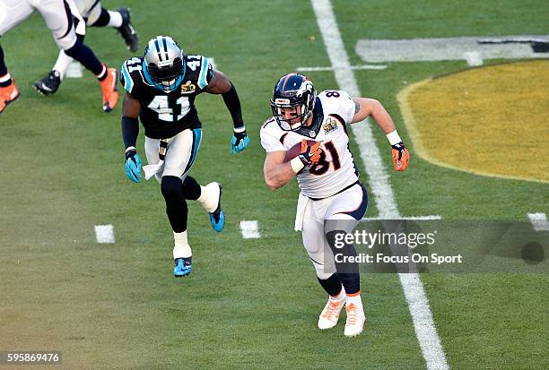 Owen Daniels of the Denver Broncos runs with the ball pursued by Roman Harper of the Carolina Panthers during Super Bowl 50 at Levi's Stadium on...