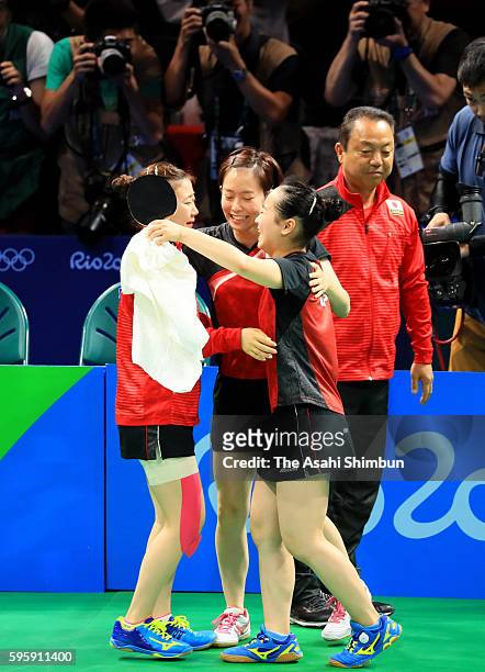 Ai Fukuhara, Kasumi Ishikawa and Mima Ito of Japan celebrate winning the bronze medals after beating Singapore in the Table Tennis Women's Team...