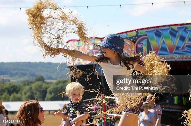 Child throws straw during The Big Feastival at Alex James' Farm on August 26, 2016 in Kingham, Oxfordshire.