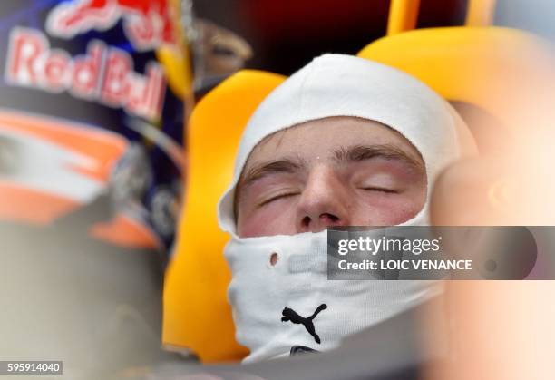 Red Bull Racing's Belgian-Dutch driver Max Verstappen closes his eyes as he sits in his car in the pits during the second practice session at the...