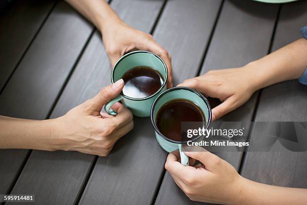 two people seated at a table, drinking coffee, viewed from above.  - sharing two people stock pictures, royalty-free photos & images