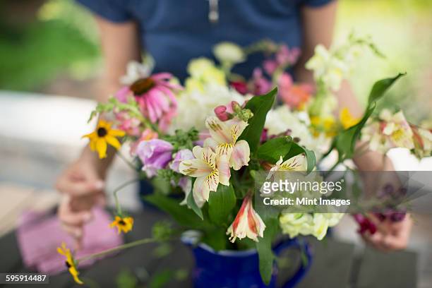 a person arranging a bunch of flowers in a vase. - arranging flowers stock pictures, royalty-free photos & images