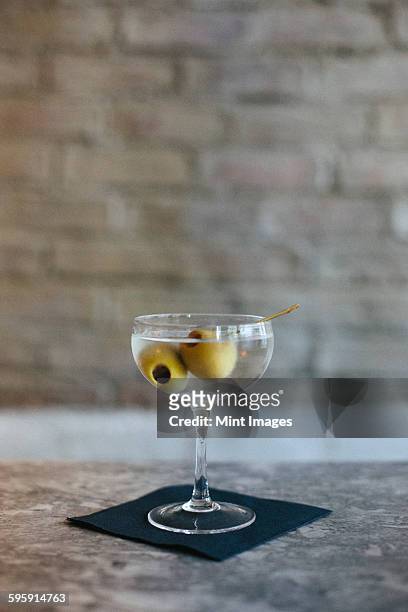 close up of a martini at a city restaurant. - green olive fruit stock pictures, royalty-free photos & images