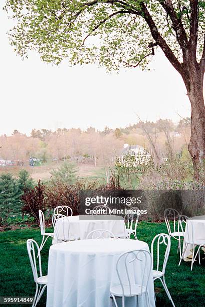 tables and chairs set with white table clothes in a hotel garden overlooking a wooded valley. - woodland cafe stock pictures, royalty-free photos & images