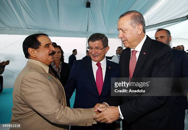 Turkish President Recep Tayyip Erdogan and King of Bahrain Hamad bin Isa al-Khalifa shake their hands as they attend the opening ceremony of newly...