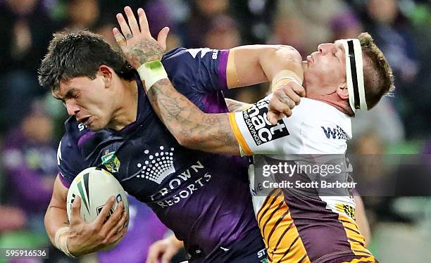 Jordan McLean of the Storm is tackled by Josh McGuire of the Broncos during the round 25 NRL match between the Melbourne Storm and the Brisbane...