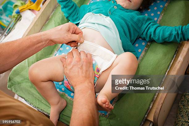 Berlin, Germany A father changes his baby's cloth diaper on August 11, 2016 in Berlin, Germany.