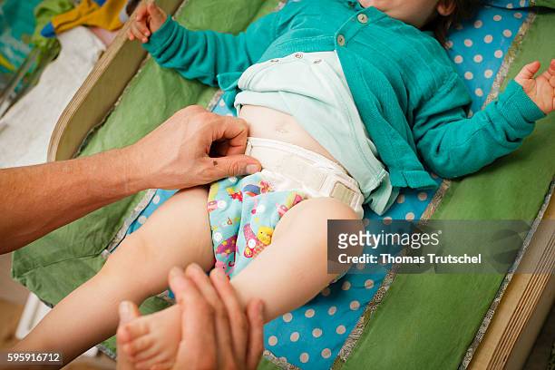 Berlin, Germany A father changes his baby's cloth diaper on August 11, 2016 in Berlin, Germany.