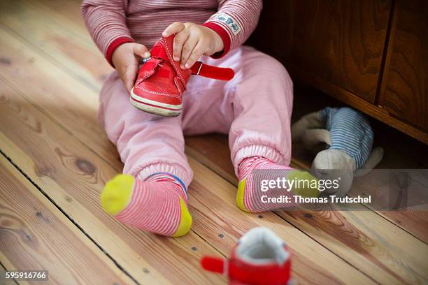 Berlin, Germany A toddler is trying to put on his shoes by himself on August 12, 2016 in Berlin, Germany.