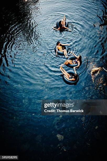 Group of four female friends floating on river