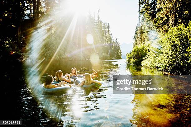 laughing friends floating on river in inner tubes - lens flare nature stock pictures, royalty-free photos & images