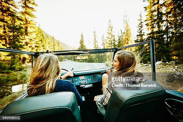 two smiling women riding in convertible - auto innenansicht stock-fotos und bilder