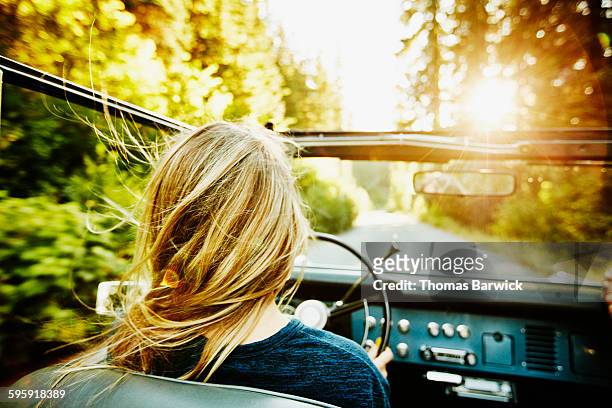 woman driving convertible on summer evening - old car stock-fotos und bilder