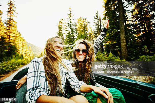 two friends riding in backseat of convertible - long live our independence stock pictures, royalty-free photos & images