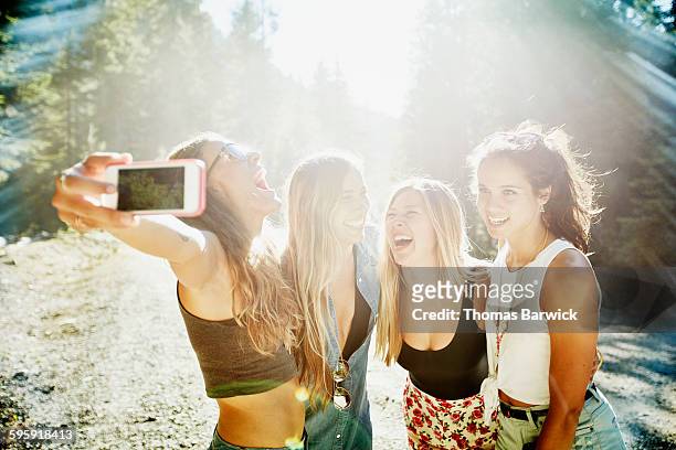laughing group of friends taking self portrait - only young women stock pictures, royalty-free photos & images