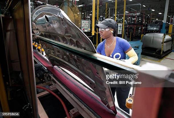 Fiat Chrysler Automobiles worker works with a hood at the FCA Sterling Stamping Plant August 26, 2016 in Sterling Heights, Michigan. An event was...