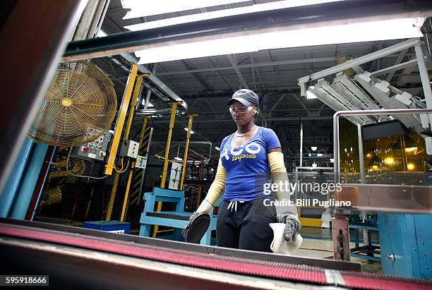 Fiat Chrysler Automobiles workers waits for a part to reach her at the FCA Sterling Stamping Plant August 26, 2016 in Sterling Heights, Michigan. An...