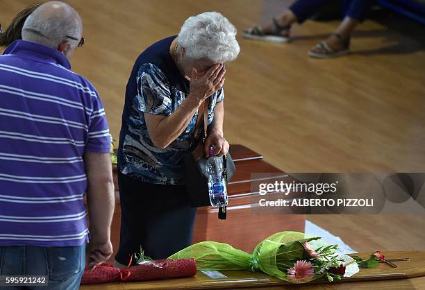 Woman mourns next to the coffin of an earthquake victim, in a gymnasium arranged in a chapel of rest on August 26 in Ascoli Piceno, two day after a...