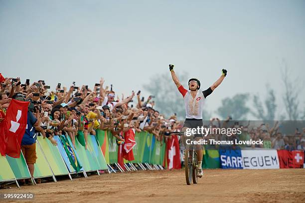 Summer Olympics: Switzerland Nino Schurter in action, victorious at the finish of the Men's Cross-Country Final at the Mountain Bike Centre. Schurter...