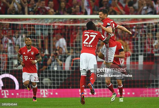 Xabi Alonso and David Alaba of Bayern Muenchen celebrate the opening goal during the Bundesliga match between Bayern Muenchen and Werder Bremen at...