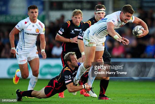 Ollie Devoto of Exeter Chiefs is tackled by Sarel Pretorius of Newport Gwent Dragons during the Pre Season Friendly match between Newport Gwent...