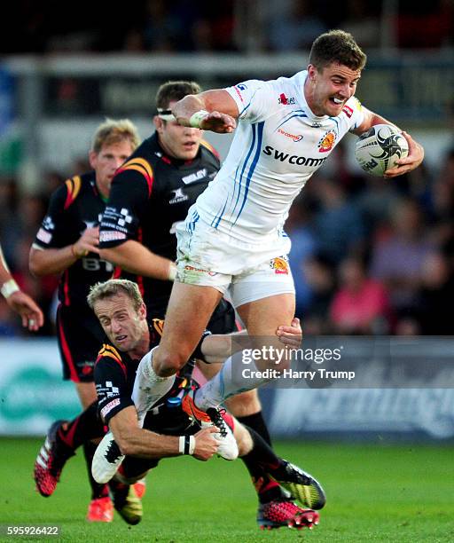 Ollie Devoto of Exeter Chiefs is tackled by Sarel Pretorius of Newport Gwent Dragons during the Pre Season Friendly match between Newport Gwent...